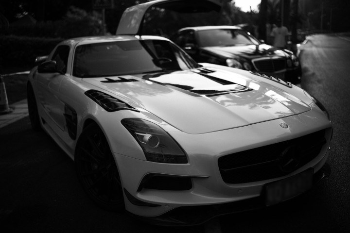 Black-and-white photo of a gullwing sportscar with the door open — automotive AM context